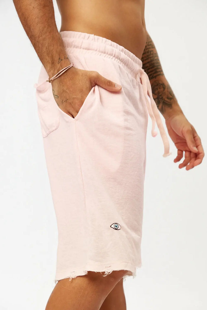Base Shorts in baby pink with a drawstring waist and an eye logo on the left leg