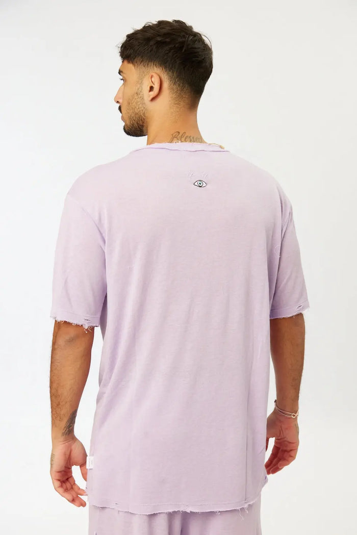 Back of a man wearing a purple Nicki Soft Open Top with a small eye graphic on the upper back