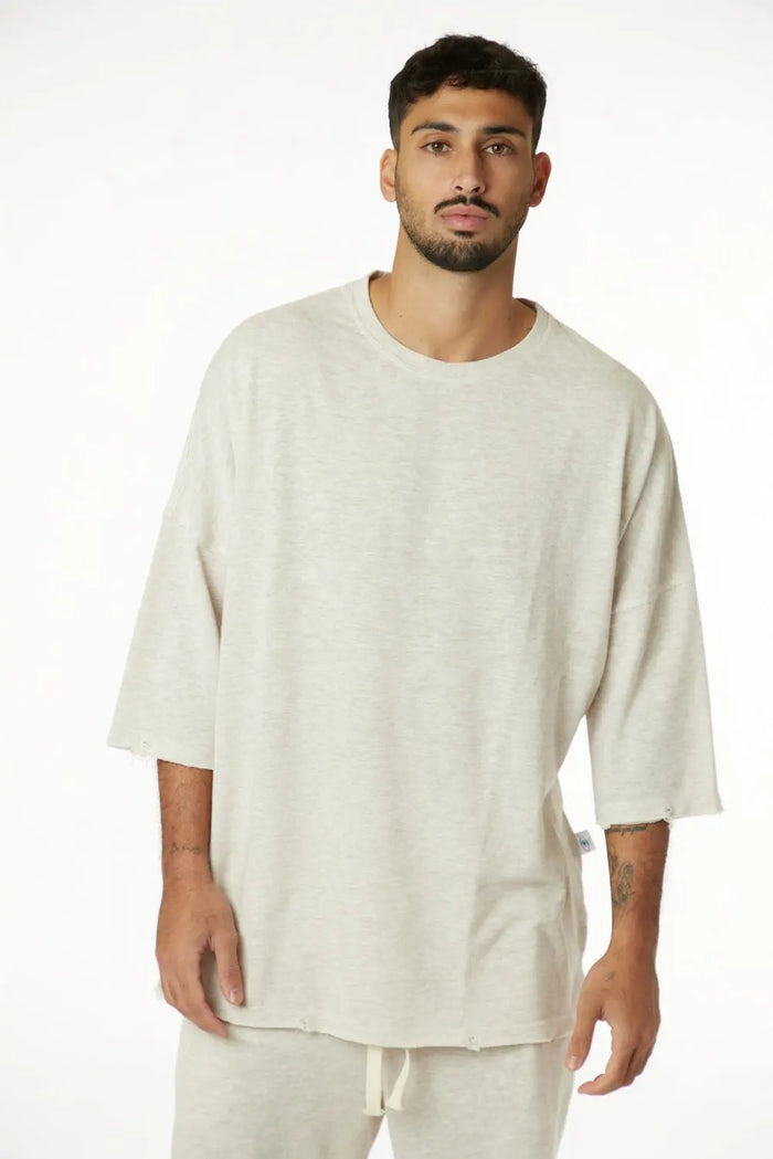 Man wearing a beige oversized shirt and pants on a white background