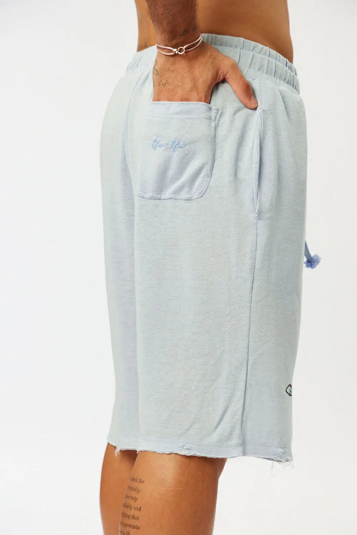 BASE Shorts in light blue, with a hand in the back pocket