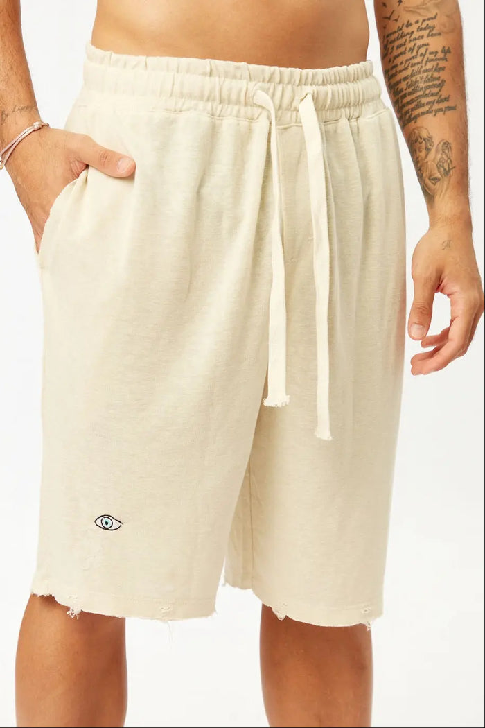 Base Shorts in Stone with an eye graphic and distressed hem