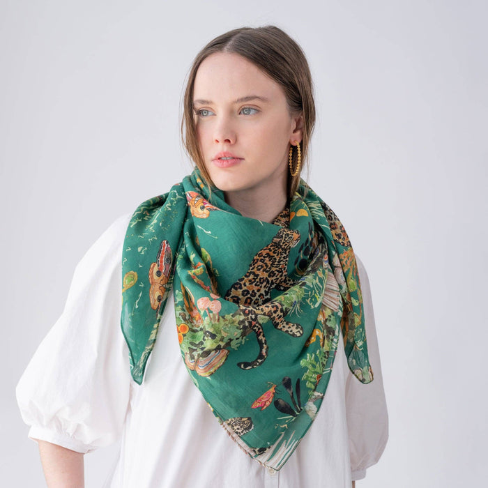 Woman wearing a green scarf with animal print on a white background