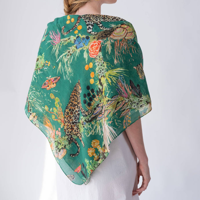 Woman wearing a colorful scarf with animal and floral patterns on a white background