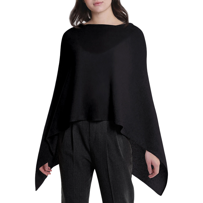 Person wearing a black poncho over a plain background