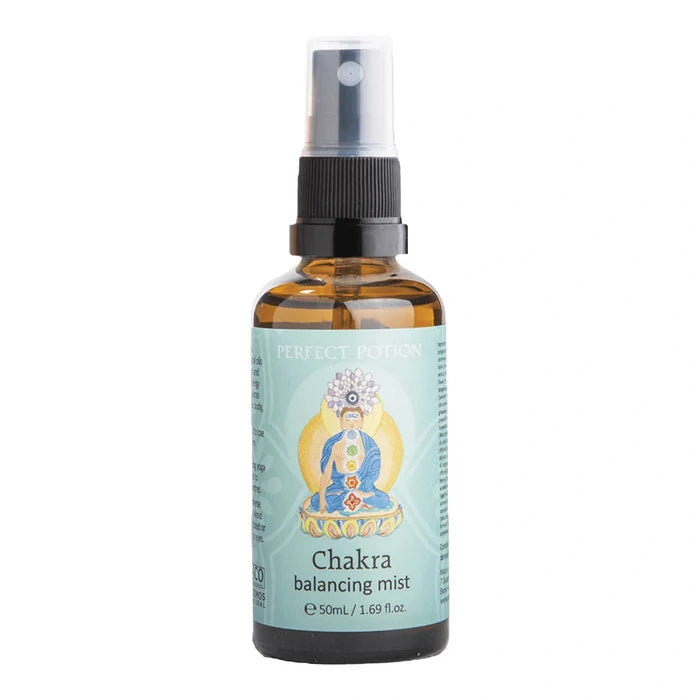 A 50 mL amber glass spray bottle of Perfect Potion Chakra Balancing Mist, featuring a light blue label with a seated deity illustration and a black spray nozzle.