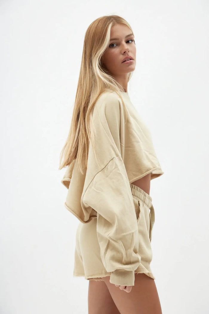 Woman wearing a beige outfit on a white background