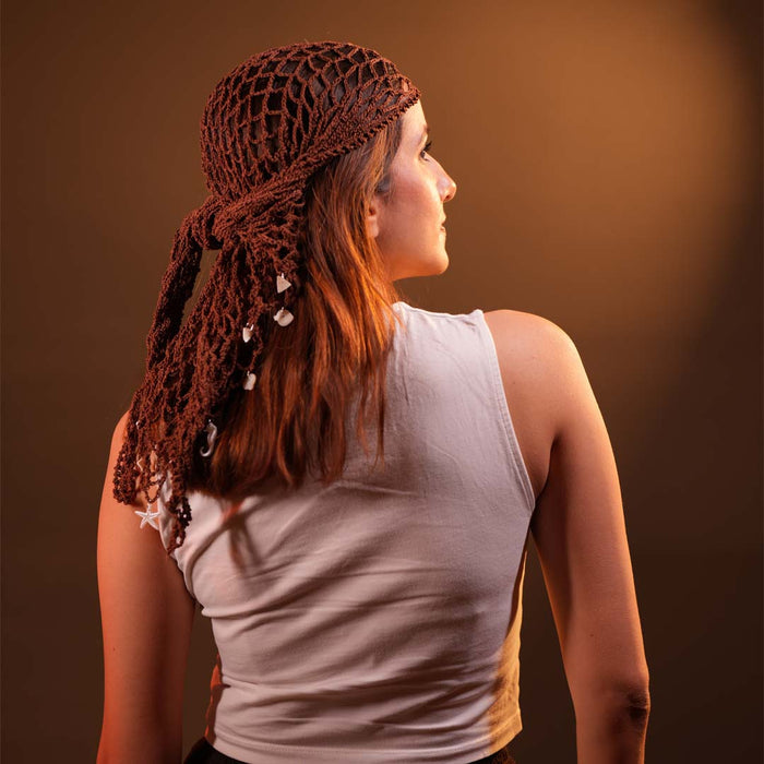 Crochet headscarf in warm brown with shell charms, worn as boho bandana hair accessory