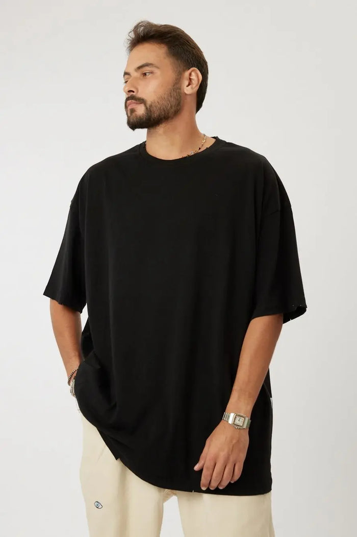 Man wearing a black cotton t-shirt and light-colored pants