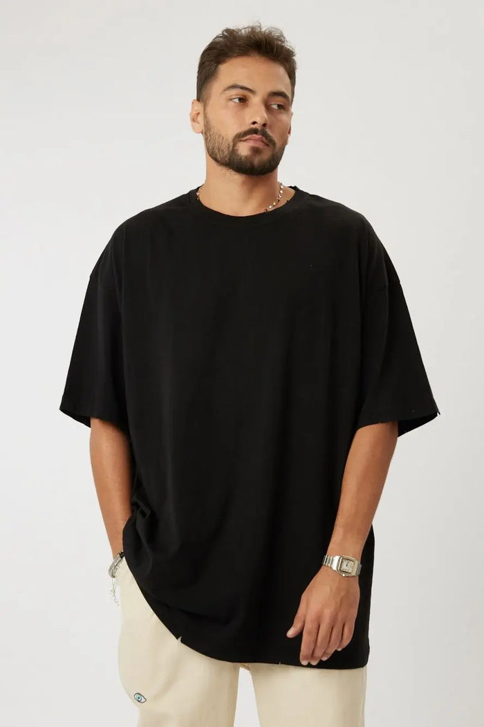 Man wearing a black Cotton T-Shirt and light-colored pants