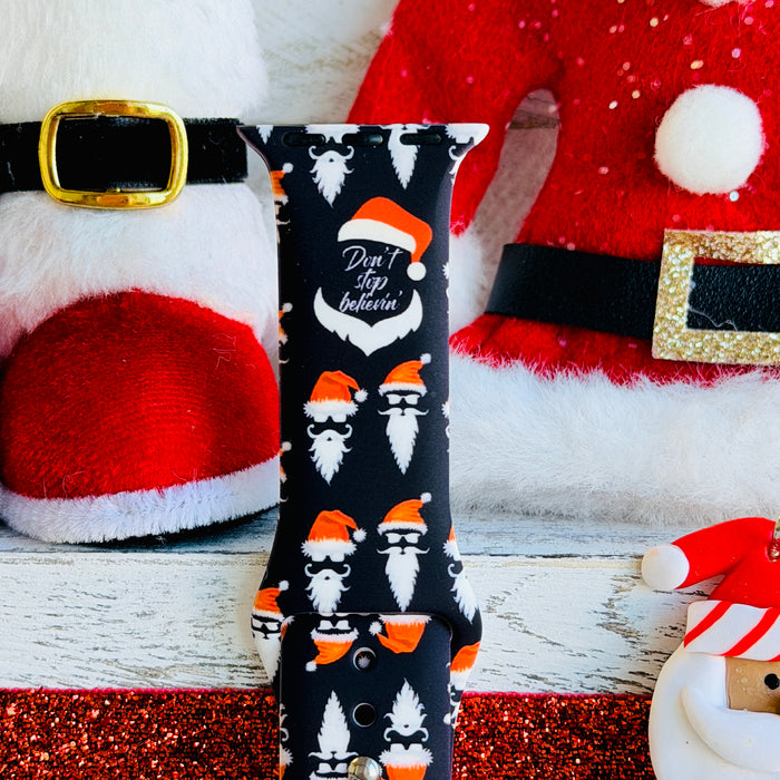 Don't Stop Believin' Apple Watch band with Santa beards and red hats on black background with Christmas decorations