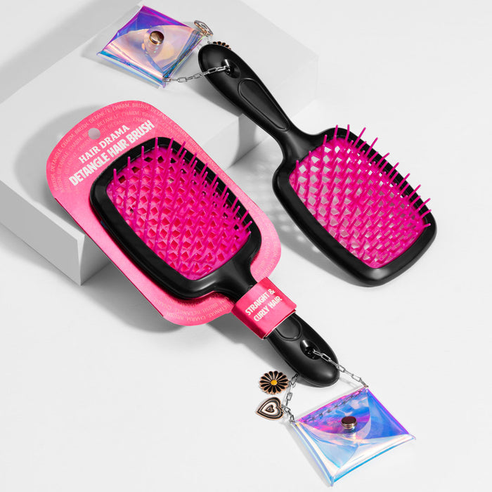 Pink and black hairbrushes with decorative charms on a white background