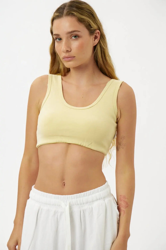 Essential Crop Top in yellow on a model with long blonde hair and white sweatpants