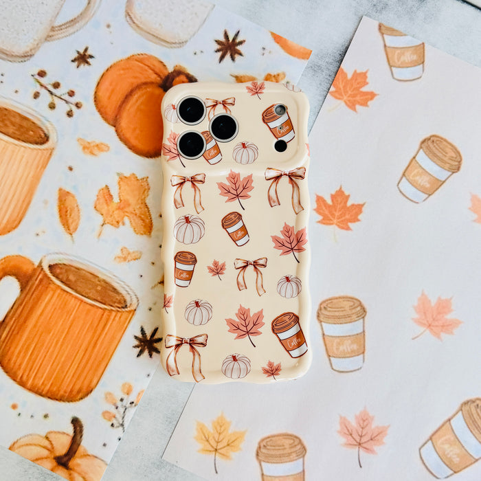 Falling in Love a Latte Wavy Luxe MagSafe iPhone case styled with a woven pumpkin basket and star anise on a coffee and pumpkin illustrated backdrop.