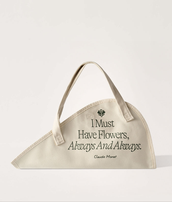 Flower Tote Monet Quote Classic. Beige flower tote with floral design and quote on a white background.