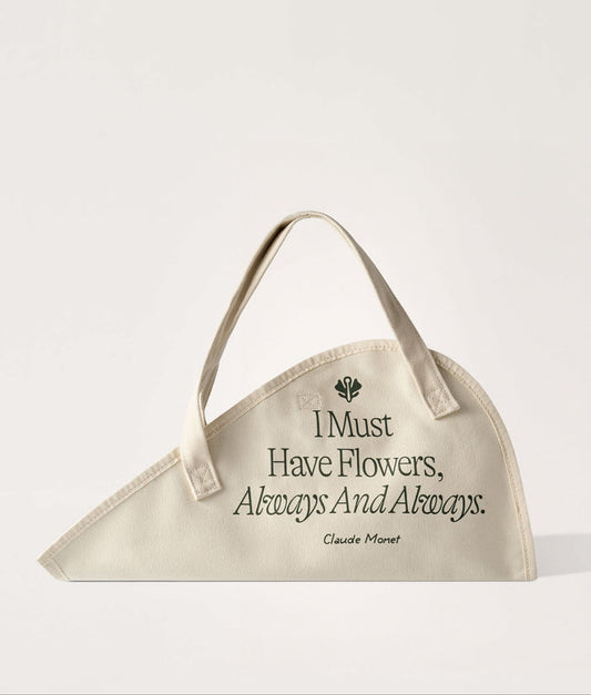 Flower Tote Monet Quote Classic. Beige flower tote with floral design and quote on a white background.