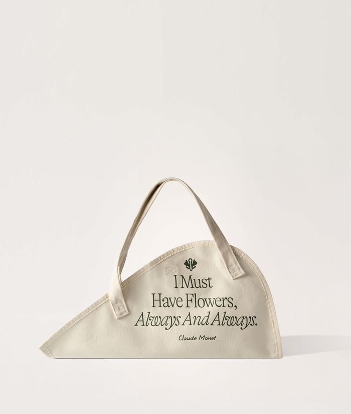 Flower Tote Monet Quote Large. Beige flower tote with floral design and quote on a white background.