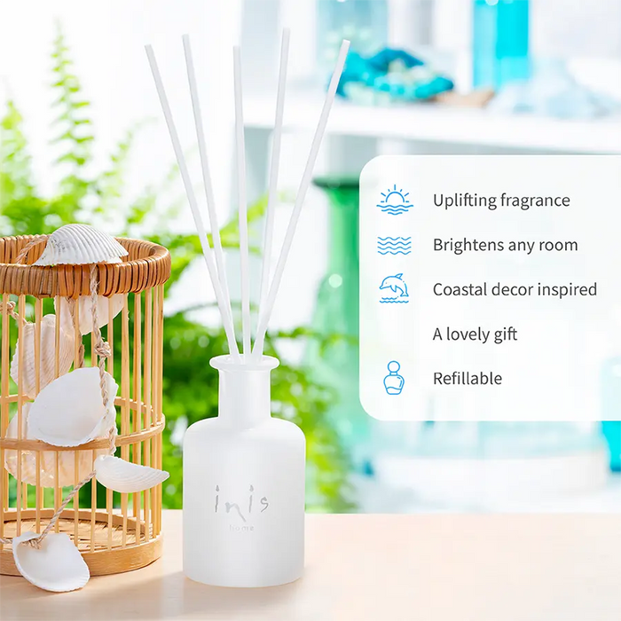 Reed diffuser with coastal decor elements on a blurred background