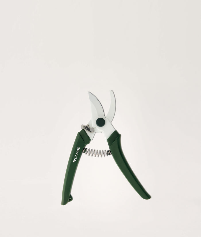 Gardening shears with green handles on a white background.
