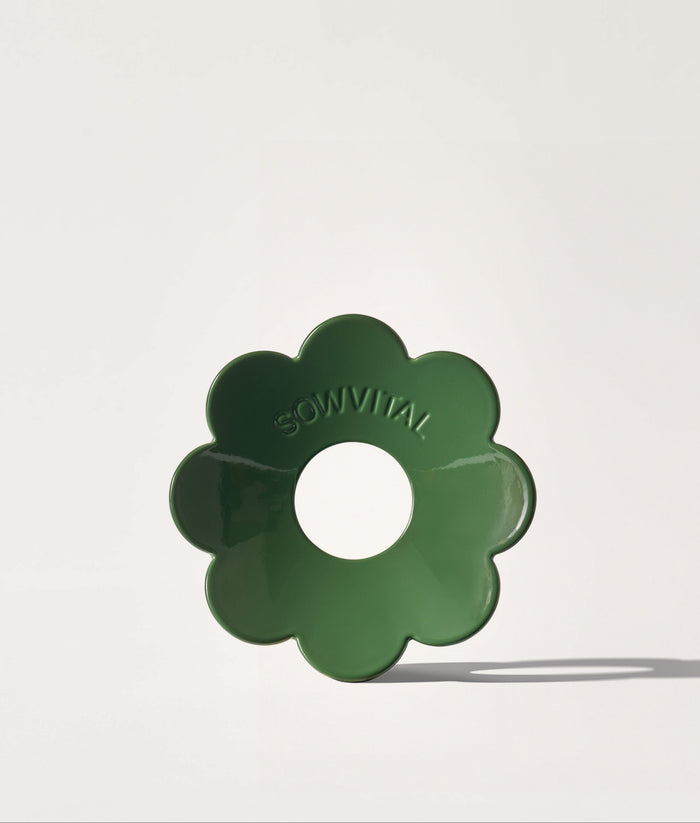Green flower-shaped germination disc on a white background.