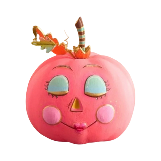 A pink decorative jack-o'-lantern pumpkin with a whimsical face, featuring closed light-blue eyes with long lashes, a small pink nose, rosy cheeks, and a striped stem topped with a small orange leaf.