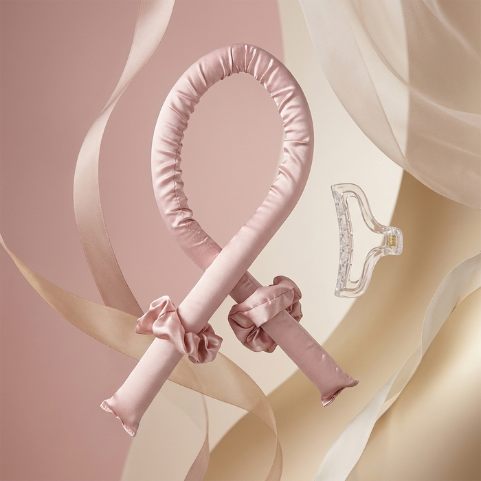 The Olla Bella Heatless Curling Heatband kit which includes our Satin Heatless Curling Headband, two satin scrunchies and a claw clip all displayed on a background of flowing satin and ribbons.