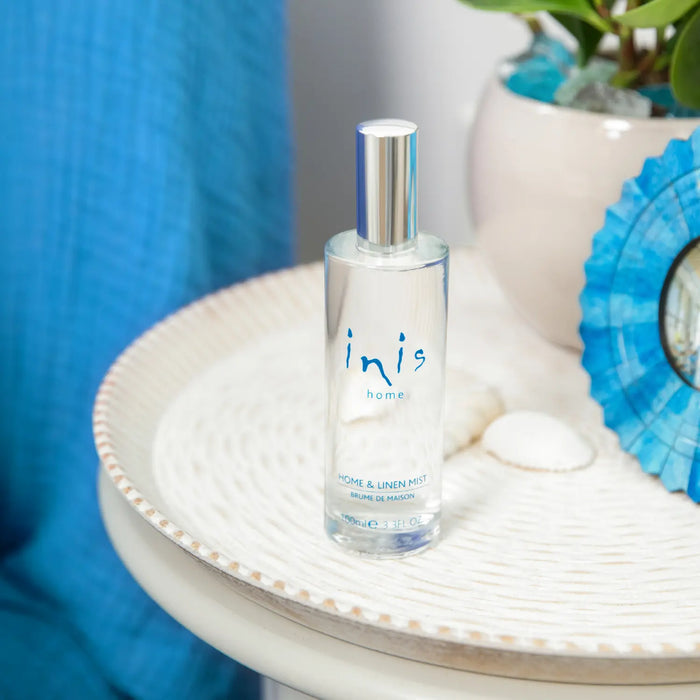Clear bottle labeled 'inis' on a decorative surface with blue and white elements.