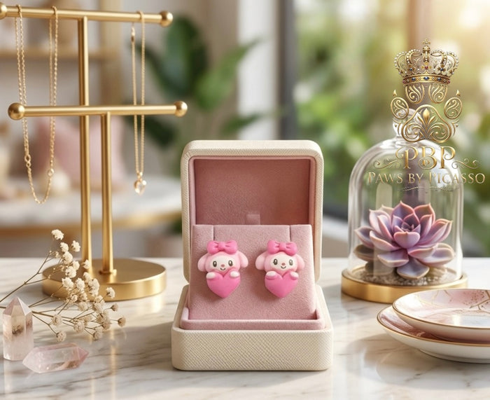 Pink earrings in a box with a decorative bottle in the background
