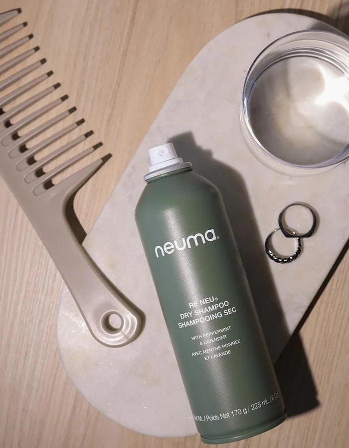 Neuma dry shampoo can with a comb and round container on a light wooden surface - Hair Care Canada
