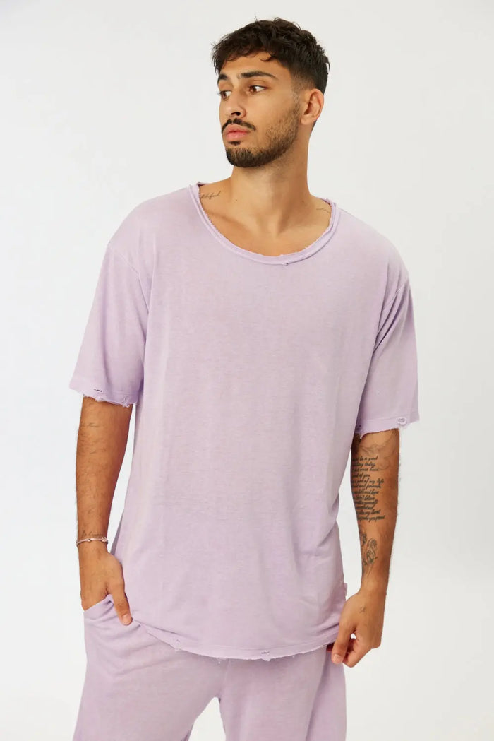 Man wearing a Nicki Soft Open Top in purple, with distressed edges on the collar and sleeves