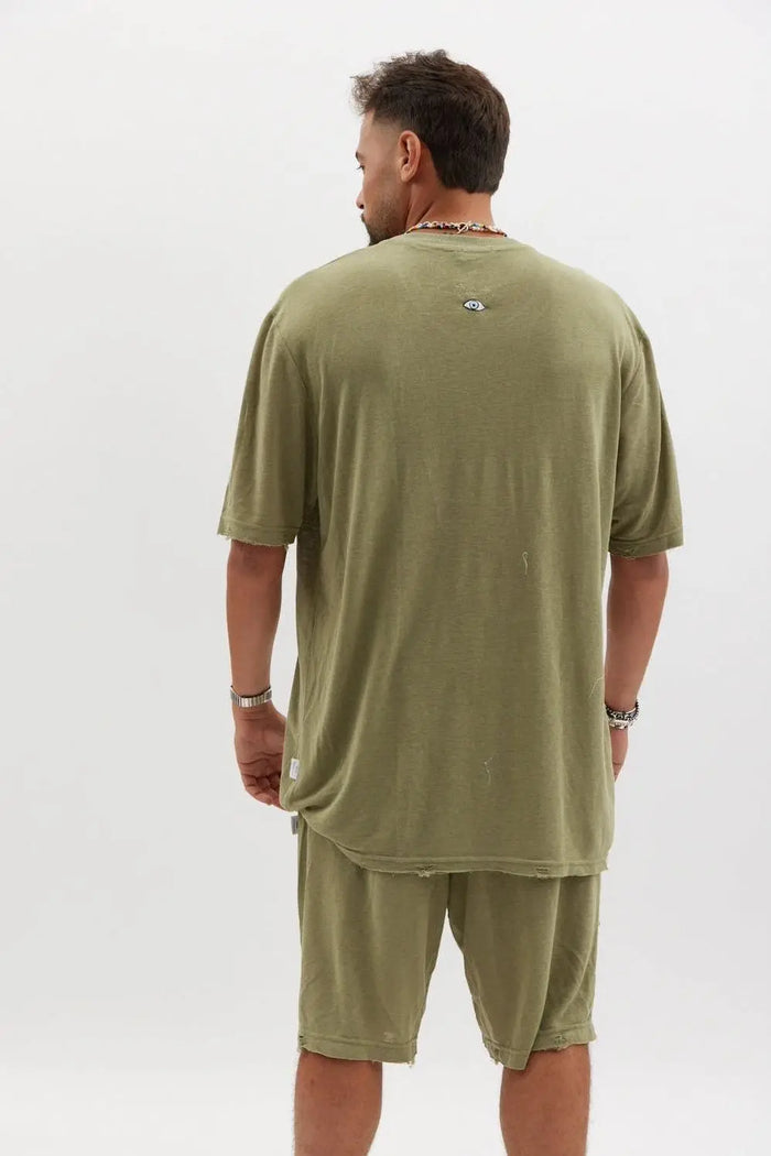 Man from behind wearing an olive TFU Soft Essential Tee and matching shorts