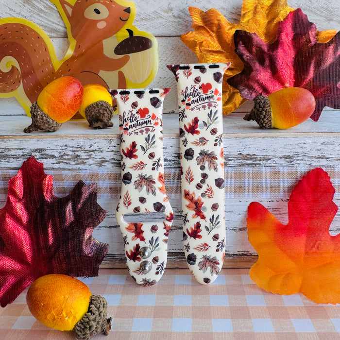 Nutty For Fall Apple Watch band with both strap halves side by side, styled with faux maple leaves, acorns, and a squirrel cutout on plaid.