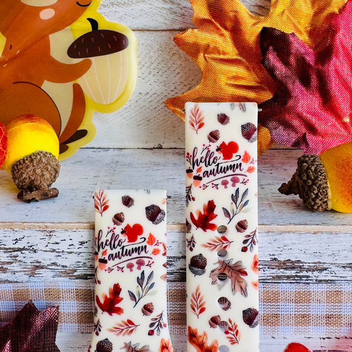 Nutty For Fall Samsung Galaxy Watch band front view of both strap halves against a squirrel and autumn leaf backdrop, showing the hello autumn lettering and acorn print.