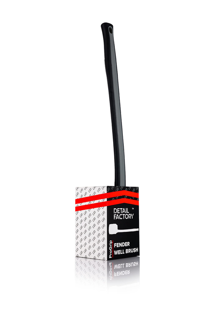 A red Detail Factory Fender Well Brush in its container on a white background.