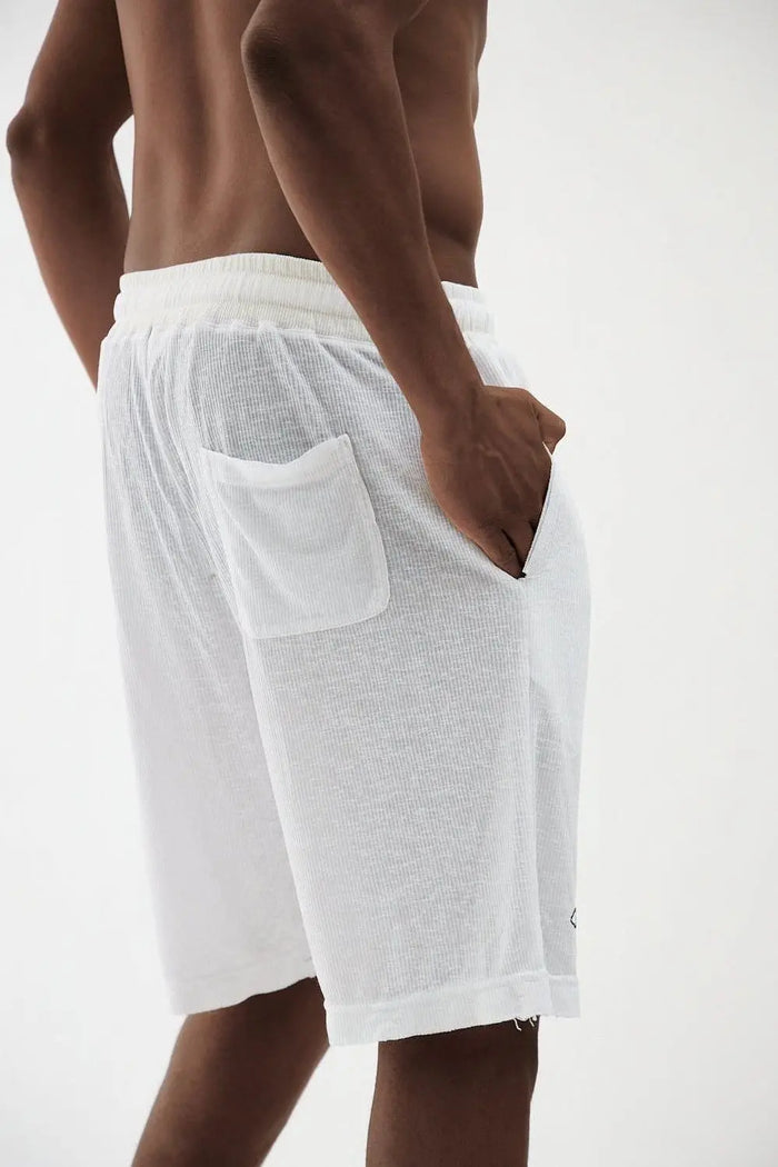 Man wearing white Rib Bermuda Shorts with an elastic waistband, side pockets, and a back patch pocket
