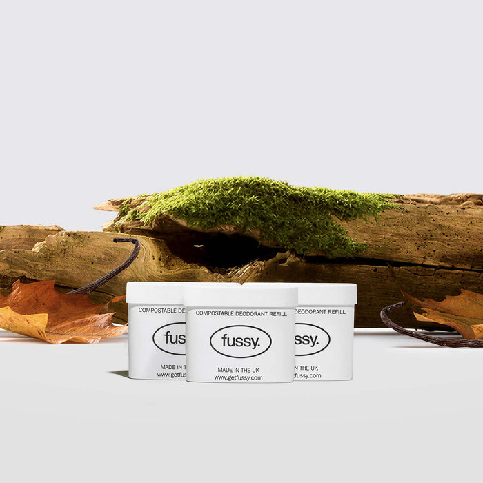 Fussy's Road Trip Refill Pack featuring three refill packs set against a backdrop of moss-covered sandalwood and tonka bean pods.