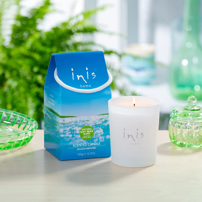 Inis home scented candle and packaging on a table with a blurred background