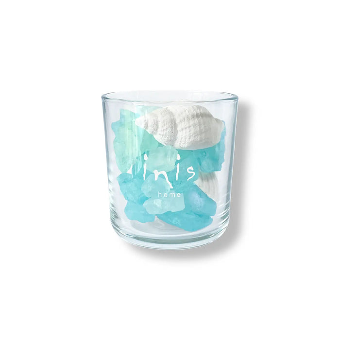 Glass tumbler with blue sea-themed design and shell on a white background