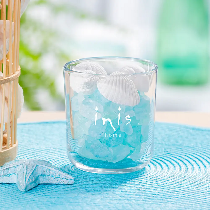 Clear glass with decorative elements on a blue textured surface, featuring 'inis home' branding.