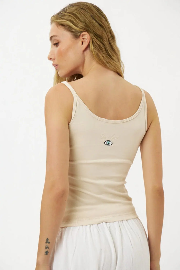 Back of a woman wearing a Slim Cotton Tank Top in Stone with an embroidered eye graphic