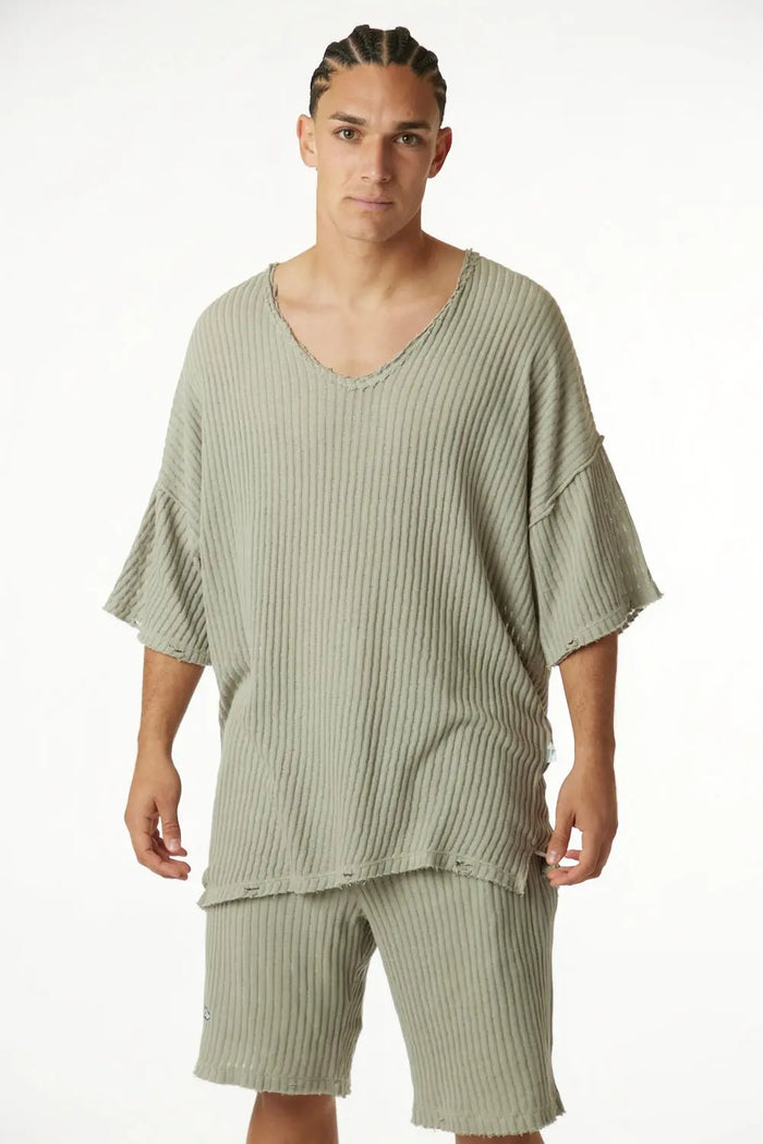 Man wearing khaki striped knit pants and matching top