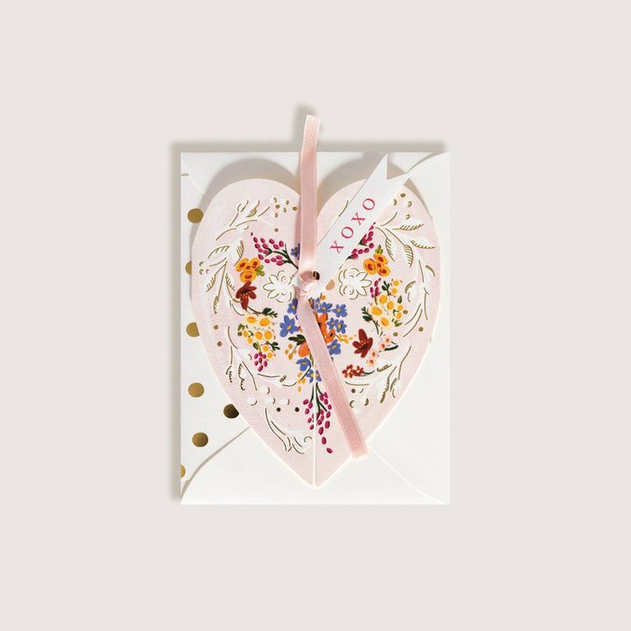 Heart-shaped card with floral design and pink ribbon on a white background