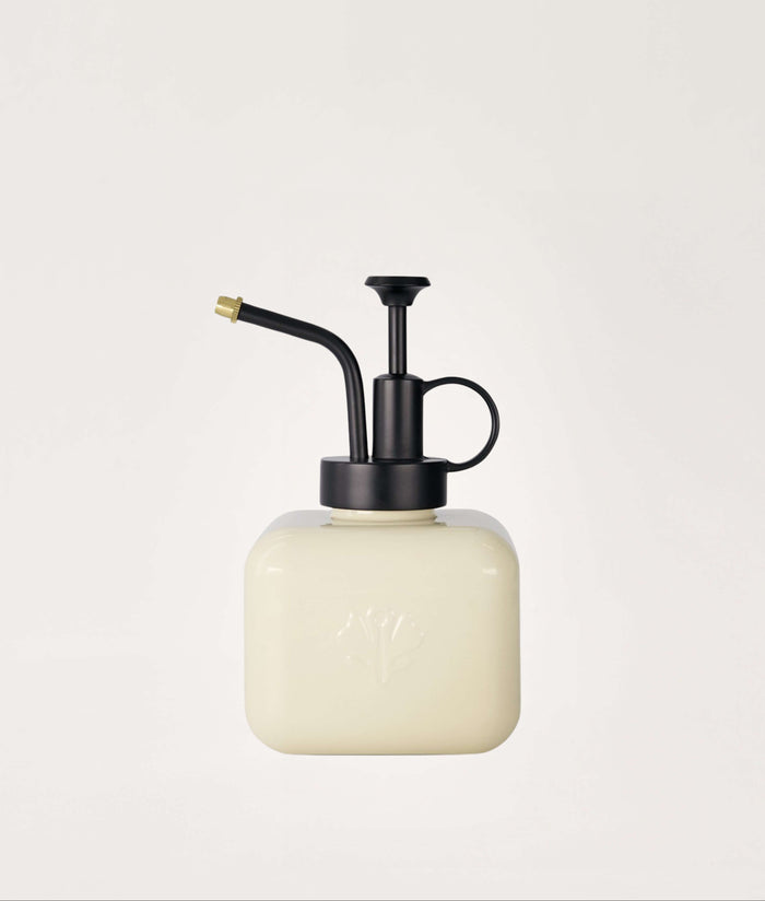 White mister with black metal nozzle on a light gray background.