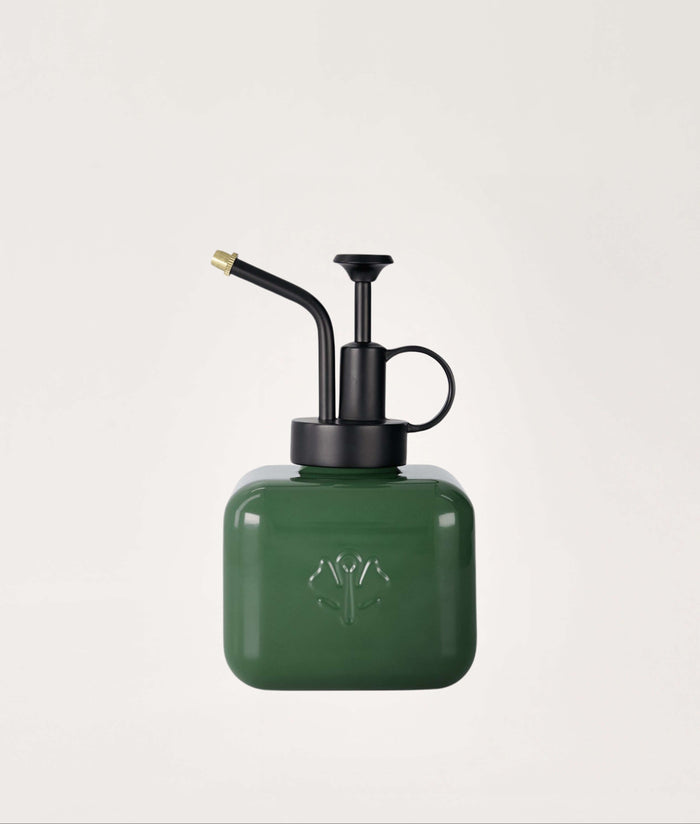 Green mister with black nozzle on a light gray background.