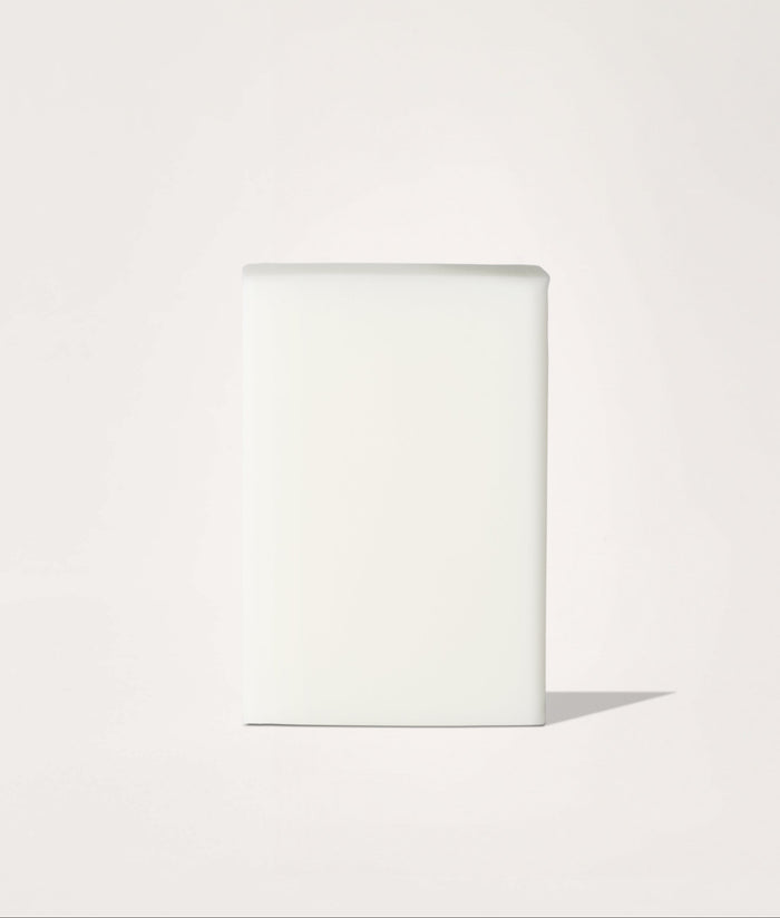 Block of white soap on a light beige background.
