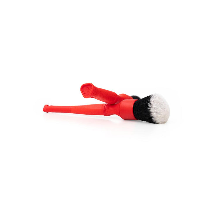 A long and short red Synthetic Detailing Brush on a white background.