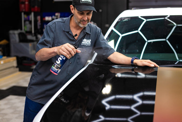 Person spraying P&S Triple S onto the hood of a car.
