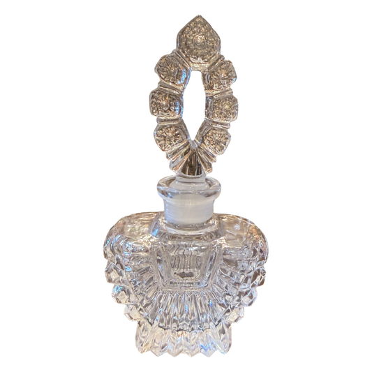 Decorative crystal perfume bottle with intricate design on a white background