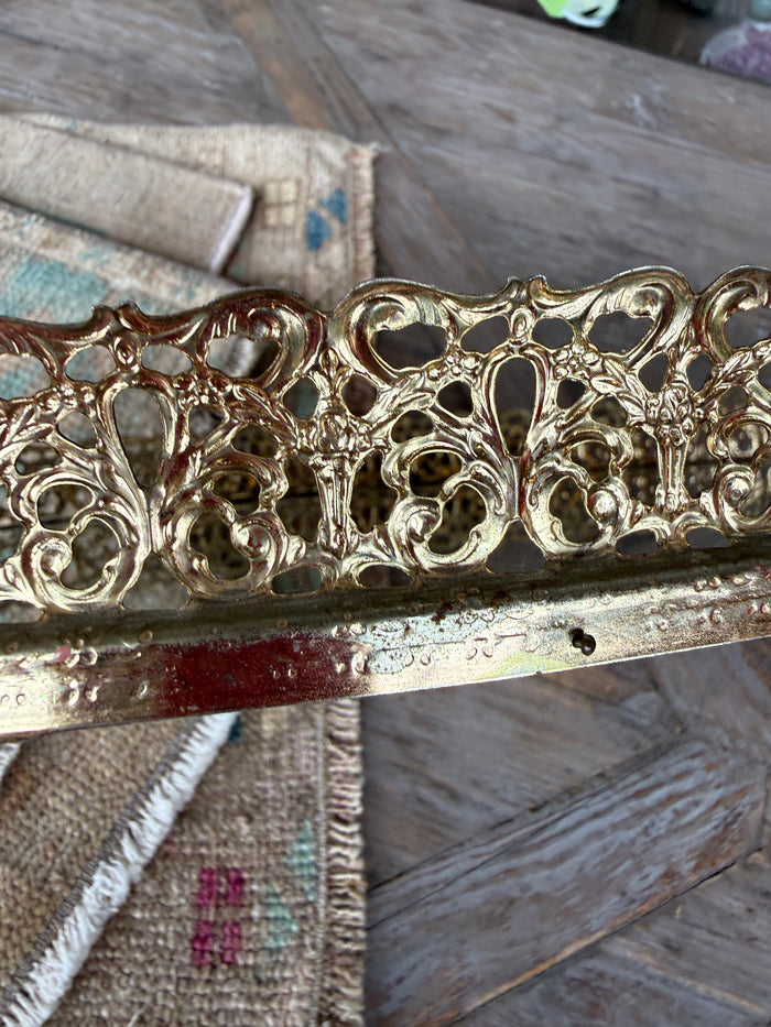 Decorative metal frame with intricate designs on a textured surface