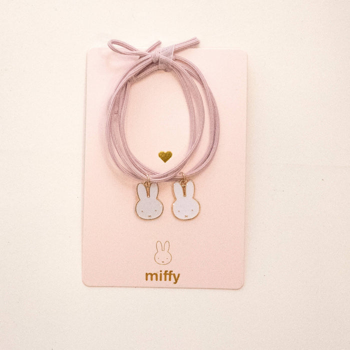 Pink hair ties with bunny charms on a pink card featuring the brand 'miffy'.